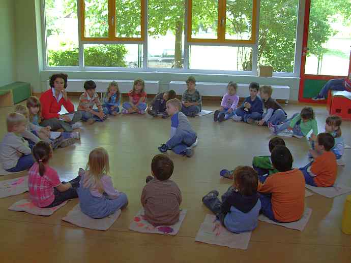 Kinder sitzen im Kreis, Redeführer in der Mitte